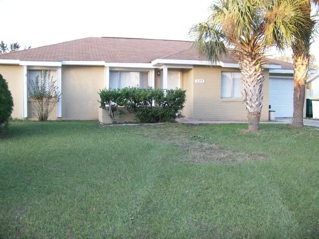 a view of a house with a yard and a garage