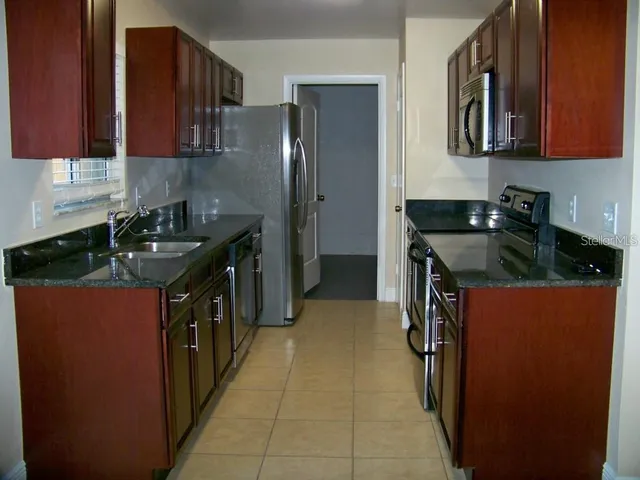 a kitchen with stainless steel appliances granite countertop a stove and a refrigerator