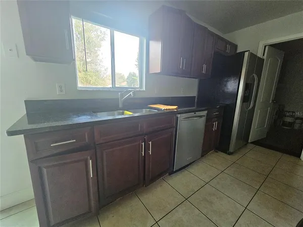 a kitchen with stainless steel appliances granite countertop a sink and a refrigerator