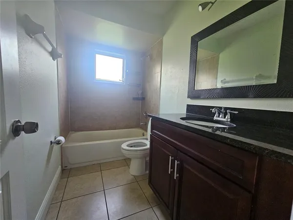 a bathroom with a granite countertop sink a toilet and mirror