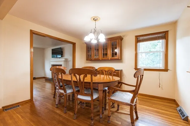 a kitchen with granite countertop a refrigerator a stove top oven and a dining table with wooden floor