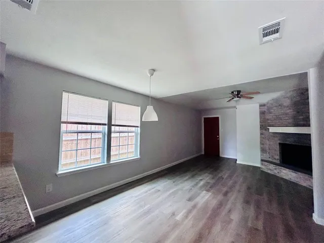 an empty room with windows and a fireplace