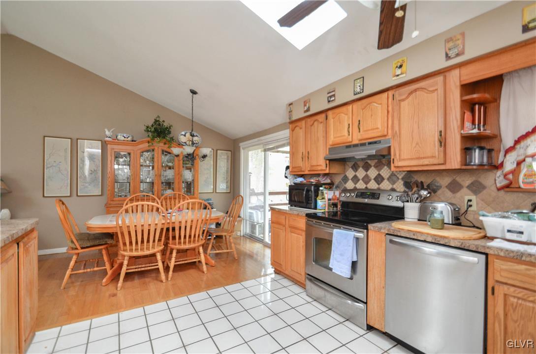253 Sundance Road Effort, PA 18330 - Photo 6 of 25 a kitchen with stainless steel appliances kitchen island granite countertop dining table chairs cabinets and a sink