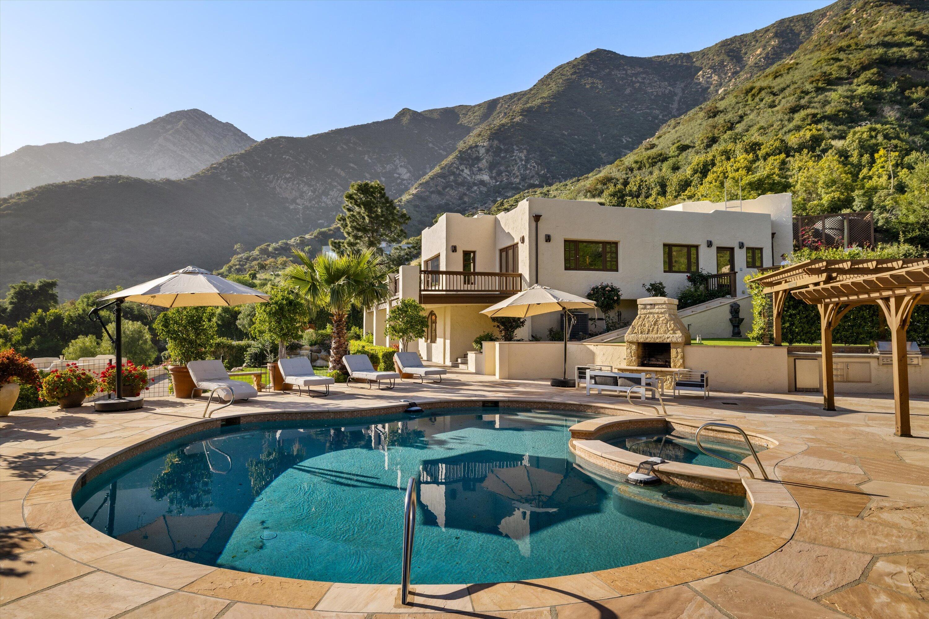 a view of a house with pool and chairs