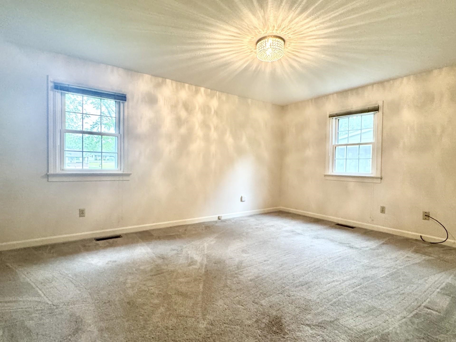 81 Middlebrook Street Harrisonburg, VA 22801 - Photo 9 of 22 an empty room with windows and chandelier fan