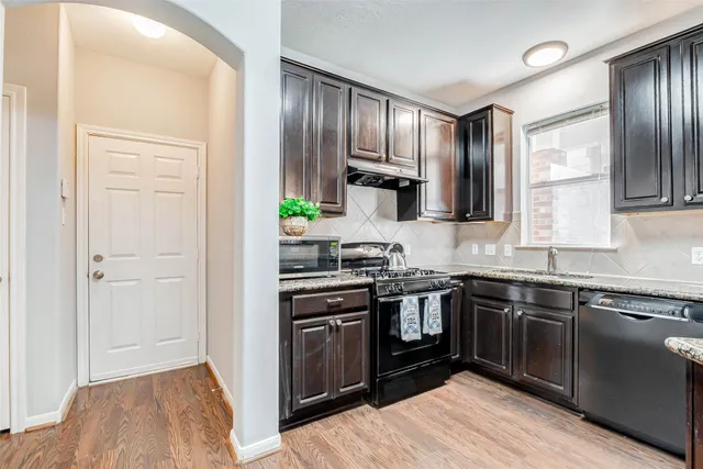 a kitchen with stainless steel appliances granite countertop a stove a sink and a refrigerator