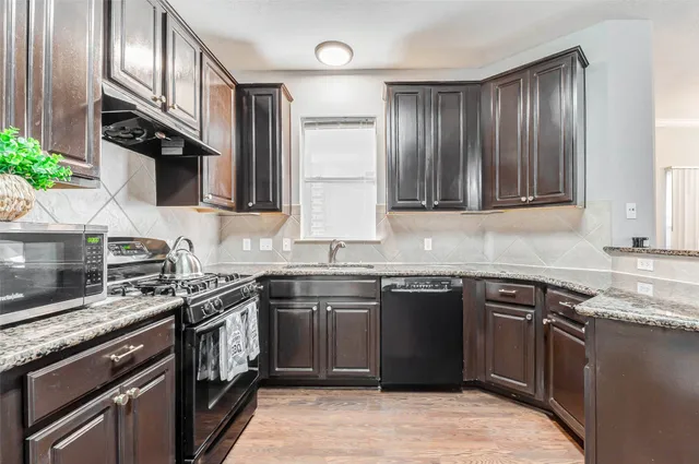 a kitchen with stainless steel appliances granite countertop a stove sink microwave and cabinets