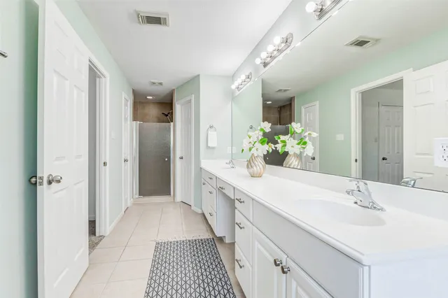 a spacious bathroom with a double vanity sink and a mirror