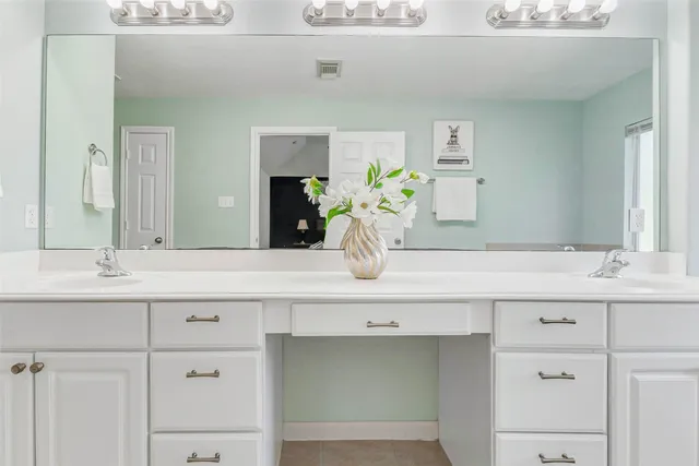 a bathroom with cabinets sink and a mirror