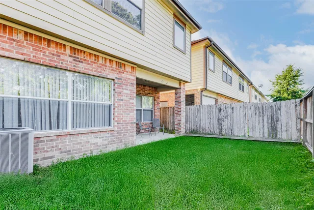 a view of a house with a yard and wooden fence