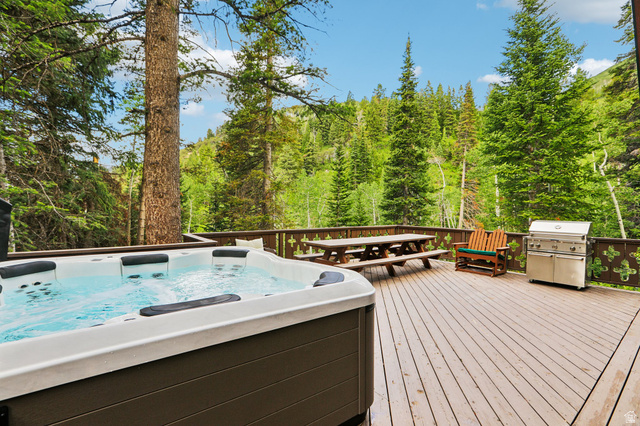 10205 East Moose Loop Road Salt Lake City, UT 84121 - Photo 36 of 50 Expansive outdoor deck featuring a hot tub, wood-finish flooring, and a decorative railing
