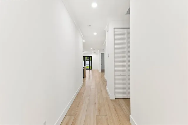 a view of a hallway with wooden floor