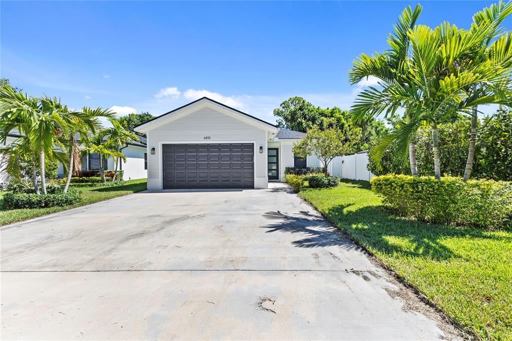 6810 Church Street Jupiter, FL 33458 - Photo 33 of 39 a front view of a house with a yard and potted plants
