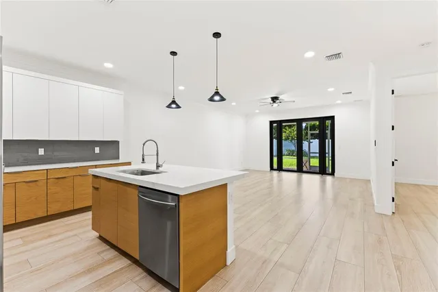 a kitchen with a sink cabinets and wooden floor