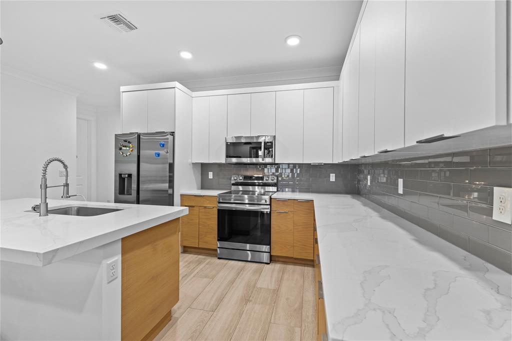 6810 Church Street Jupiter, FL 33458 - Photo 6 of 39 a large kitchen with stainless steel appliances granite countertop a stove a sink and a microwave