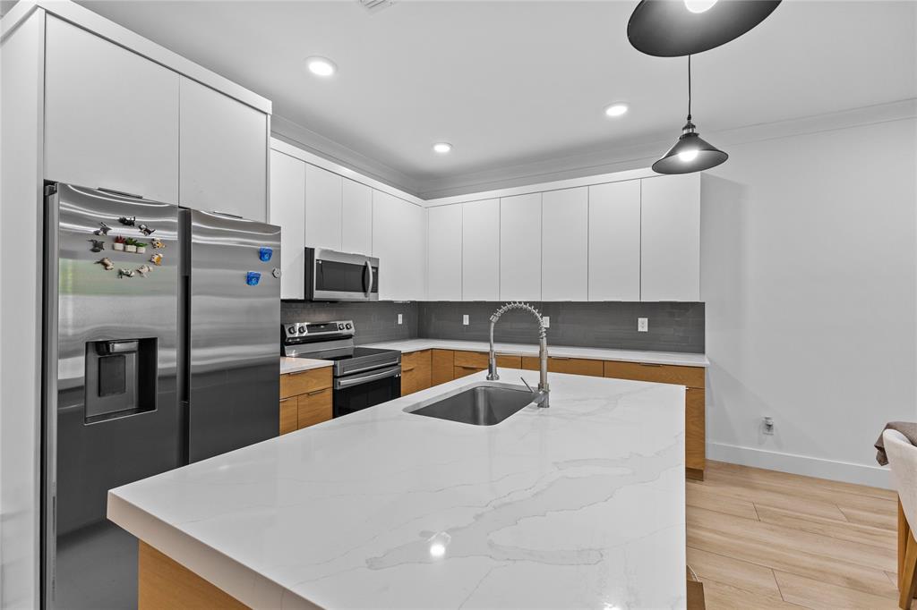 6810 Church Street Jupiter, FL 33458 - Photo 7 of 39 a kitchen with stainless steel appliances granite countertop a sink a stove a refrigerator and island