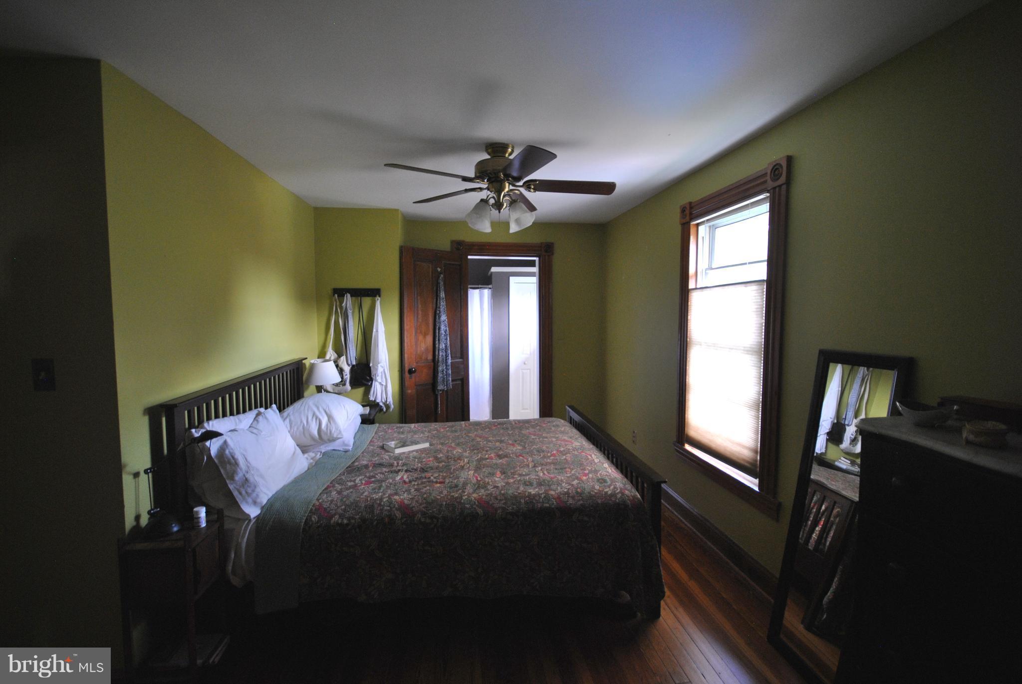 5939 Falls Road Baltimore, MD 21209 - Photo 14 of 20 a bedroom with a bed and a chandelier