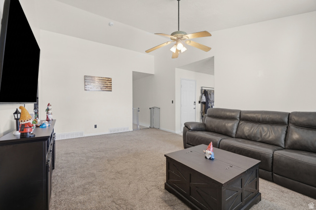2135 East White Pine Road Eagle Mountain, UT 84005 - Photo 5 of 23 Carpeted living area featuring a ceiling fan with integrated lighting, neutral wall tones, and recessed wall space