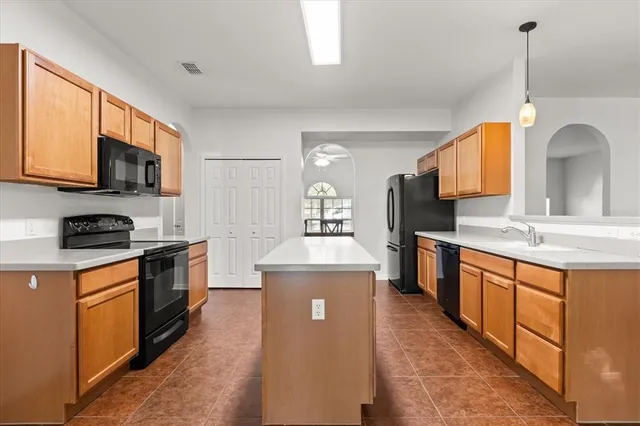 a kitchen with stainless steel appliances granite countertop a sink a stove top oven a counter space and cabinets