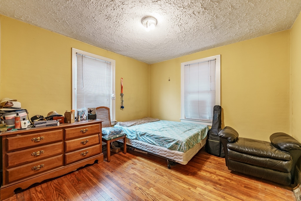 170 Eddy Street Springfield, MA 01104 - Photo 17 of 25 a bedroom with a bed and wooden floor