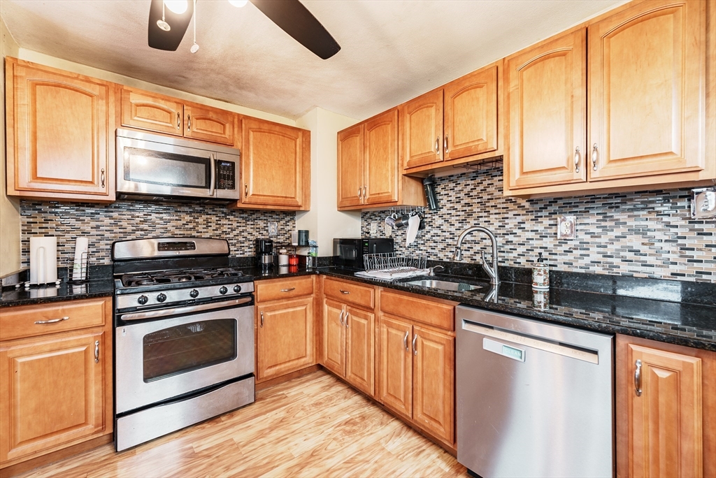170 Eddy Street Springfield, MA 01104 - Photo 5 of 25 a kitchen with stainless steel appliances granite countertop a stove sink microwave and cabinets