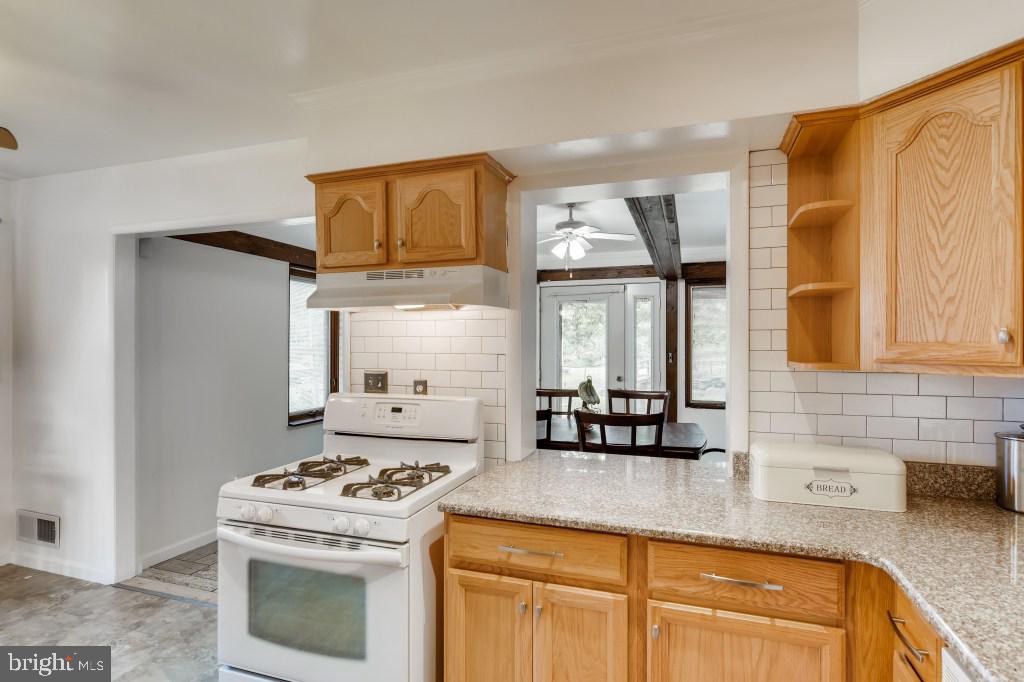 3714 Campfield Road Baltimore, MD 21207 - Photo 11 of 32 a kitchen with granite countertop a stove a sink and a granite counter tops
