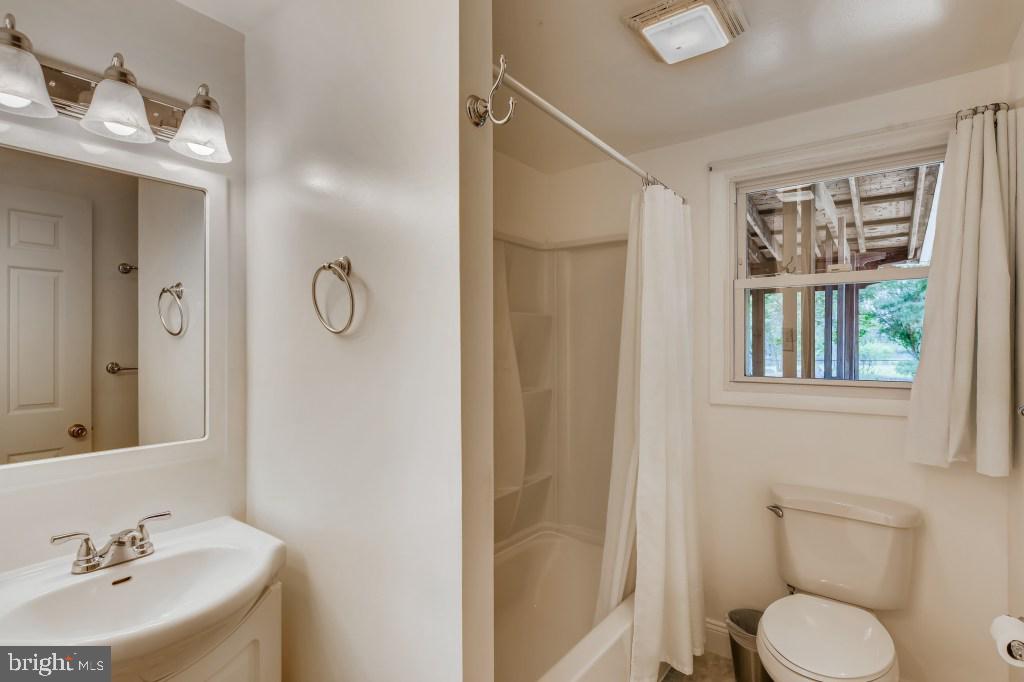 3714 Campfield Road Baltimore, MD 21207 - Photo 18 of 32 a bathroom with a toilet sink a mirror and shower