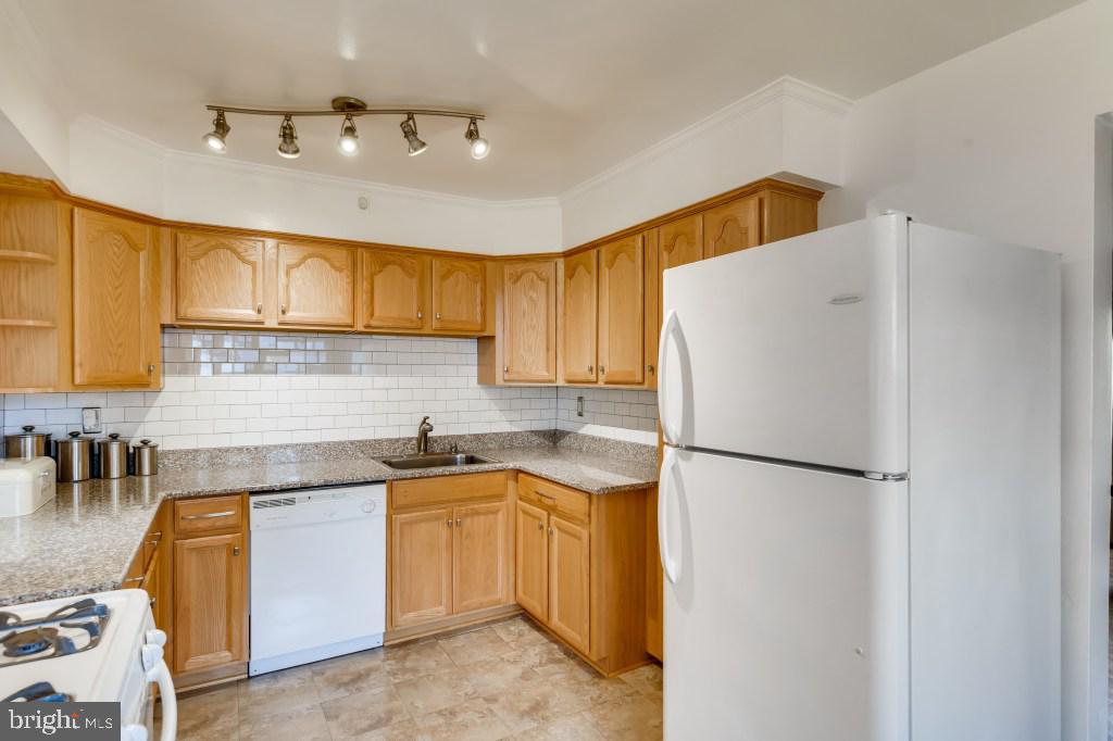 3714 Campfield Road Baltimore, MD 21207 - Photo 8 of 32 a kitchen with a sink a refrigerator and cabinets