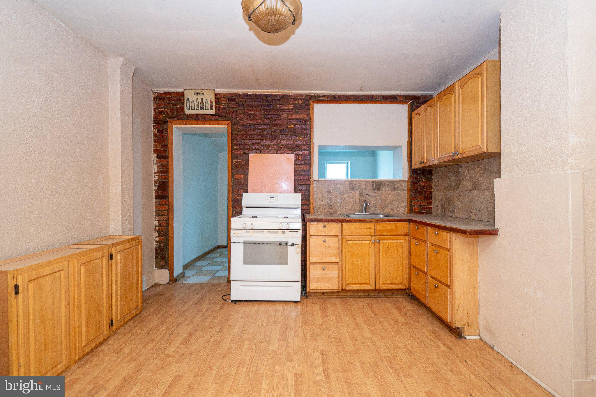 423 Furrow Street Baltimore, MD 21223 - Photo 11 of 24 a kitchen with granite countertop a refrigerator and a stove top oven