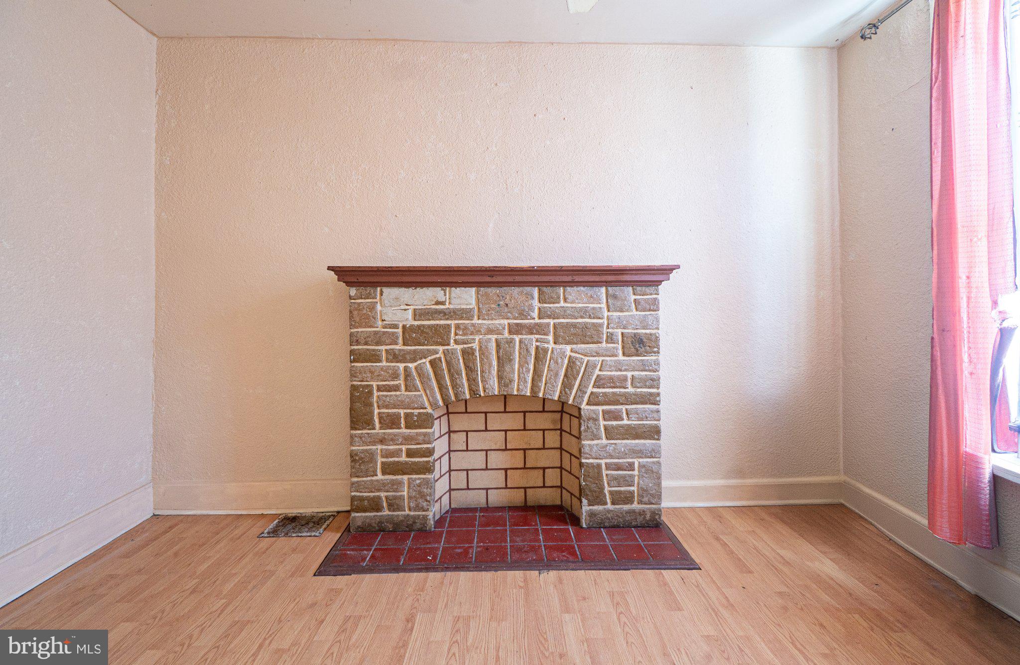 423 Furrow Street Baltimore, MD 21223 - Photo 6 of 24 a view of an empty room with wooden floor and a window