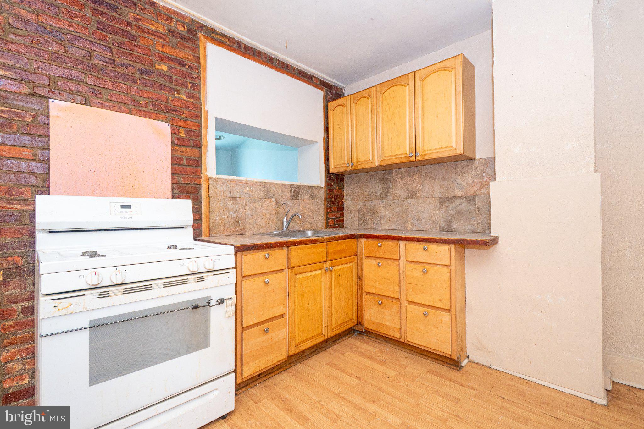423 Furrow Street Baltimore, MD 21223 - Photo 10 of 24 a kitchen with granite countertop white cabinets and white appliances