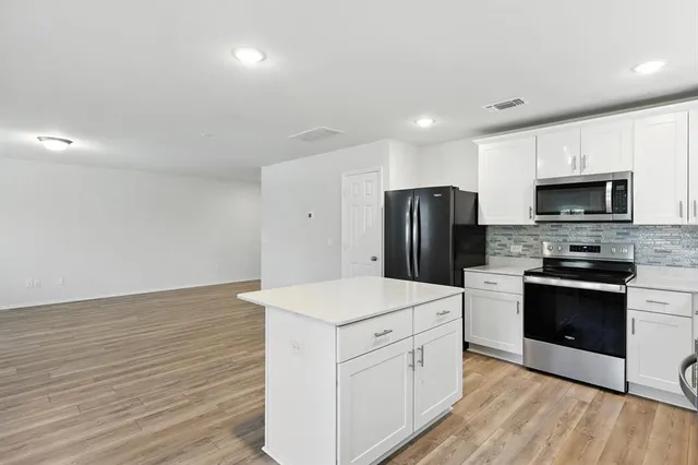 a kitchen that has a sink stainless steel appliances a counter space and cabinets
