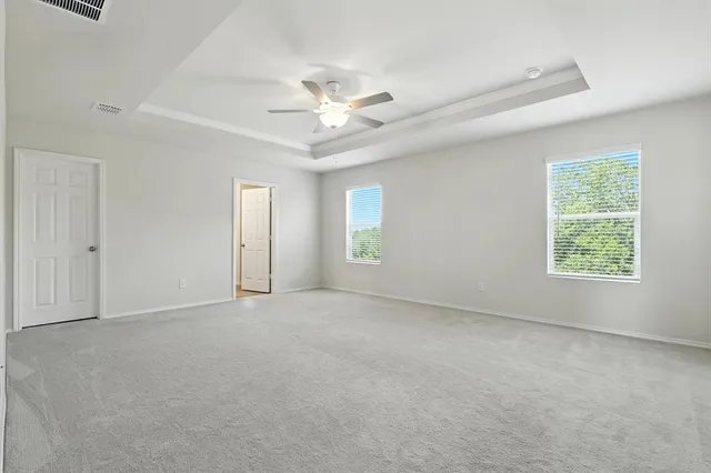 an empty room with windows and fan