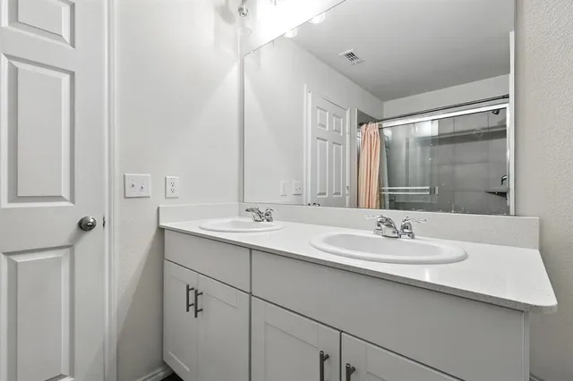 a bathroom with a sink double vanity and a mirror