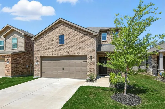 a front view of a house with a garden and yard