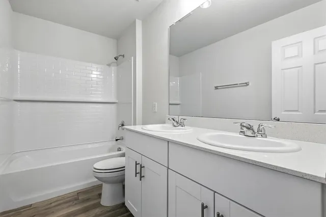 a bathroom with a double vanity sink toilet mirror and shower