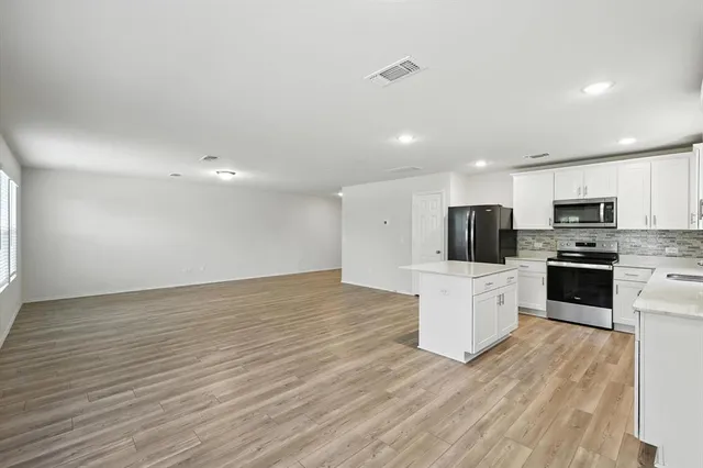 a kitchen with stainless steel appliances a refrigerator sink and microwave
