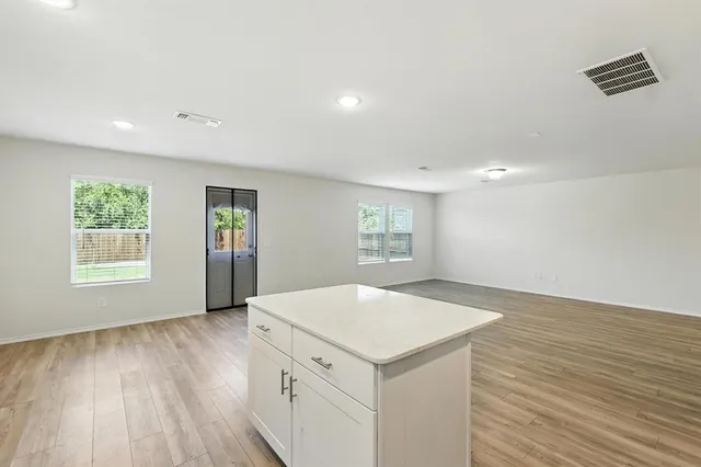 a view of empty room with wooden floor and window