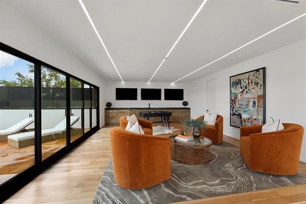 9457 Waterview Road Dallas, TX 75218 - Photo 24 of 25 Spacious entertainment room featuring recessed linear lighting and wood-finish flooring