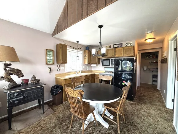 a kitchen with a table chairs sink and cabinets