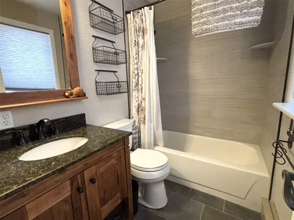 a bathroom with a granite countertop sink toilet and shower