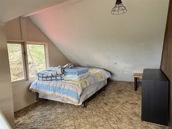 a bed sitting in a bedroom next to a window