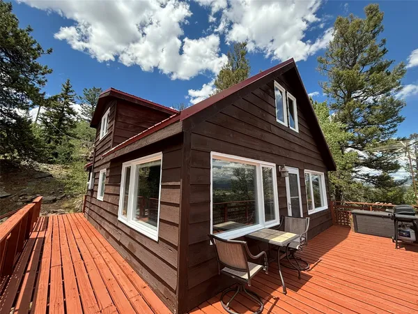 a balcony with wooden floor table and chairs