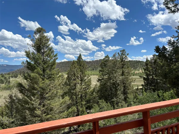 a backyard of a house with table and chairs under an umbrella