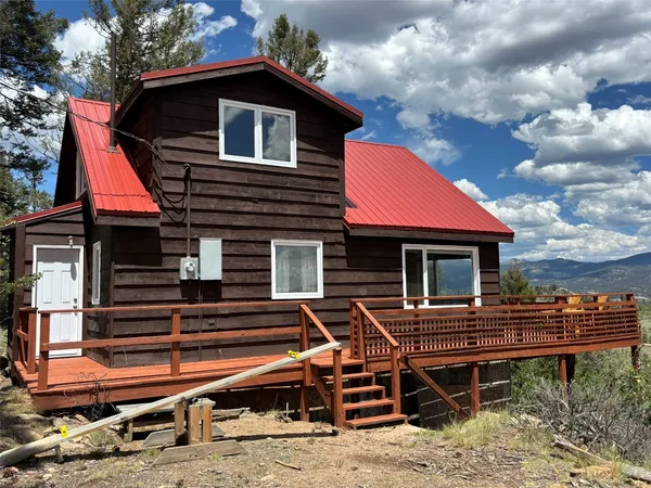 a backyard of a house with wooden deck and furniture