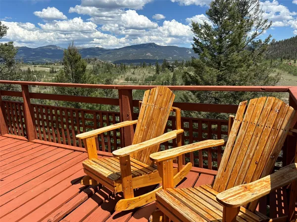 a view of a balcony with wooden floor and outdoor seating