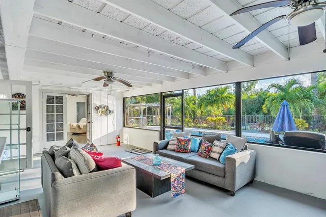 a living room with furniture ceiling fan and a large window