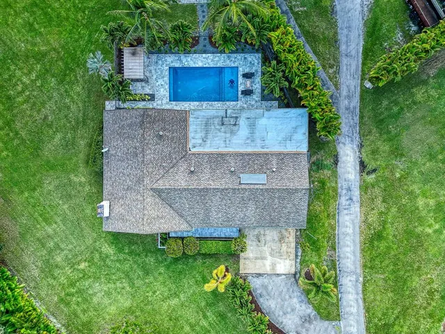 an aerial view of a house with a yard and large tree