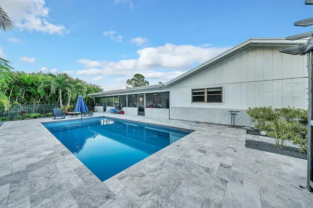 a view of a house with swimming pool and porch with furniture