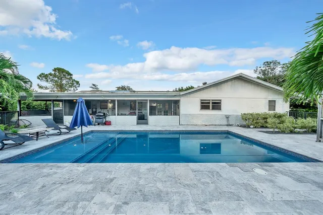 a view of a swimming pool with chair and table